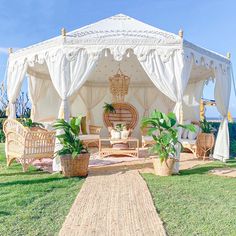 a white gazebo sitting on top of a lush green field