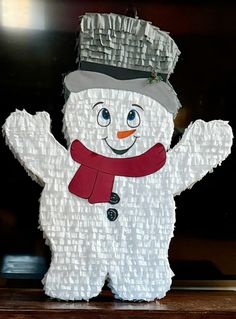 a paper snowman with a hat and scarf