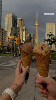 two people holding ice cream cones in their hands