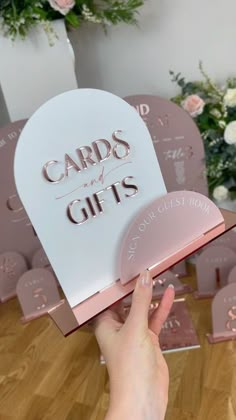 a person holding up a card that says cards for girls in front of some flowers