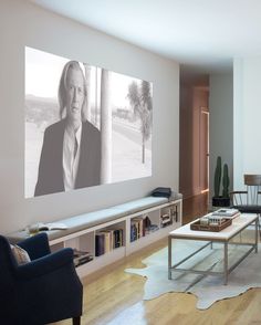 a living room filled with furniture and a large screen tv mounted to the side of a wall