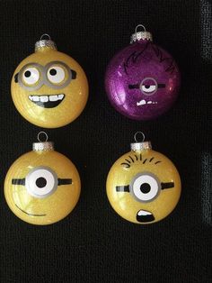 four yellow and purple ornaments with faces on them