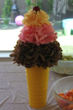 a yellow vase filled with flowers on top of a table