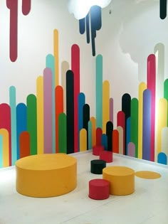 an art installation with colorful lines painted on the wall and stools in front of it