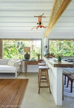 a living room filled with furniture next to a kitchen and an open floor plan on the wall