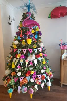 a decorated christmas tree with pink flamingos and other decorations on it's top