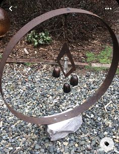 a metal sculpture sitting on top of a pile of rocks