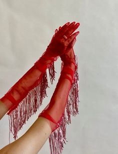 two hands in red gloves are holding each other's arms with their fingers together