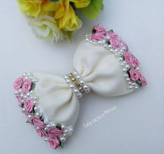 two white bows with pink roses and pearls