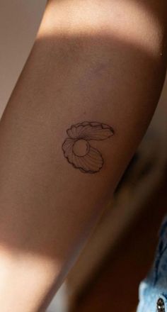 a woman's arm with a flower tattoo on the left side of her arm