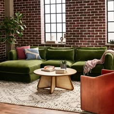 a living room with brick walls and green couches