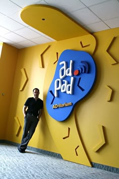 a man standing in front of a sign for an appliance store that is yellow and blue