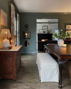 a living room filled with furniture and a fire place next to a table in front of a fireplace