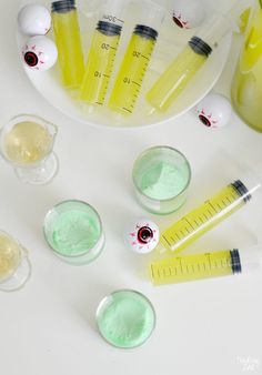 several medical supplies are arranged on a white counter top with measuring cups and beakles