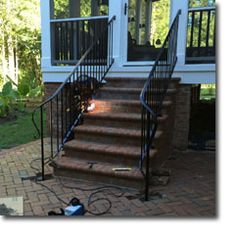 a set of stairs leading up to a door with a blower on the ground next to it