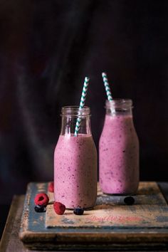 two mason jars filled with berry smoothie