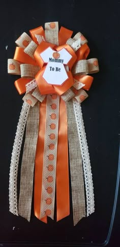 an orange and white ribbon with the words mommy to be on it