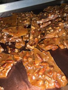 there are many pieces of chocolate and nuts on the trays that have been cut into squares