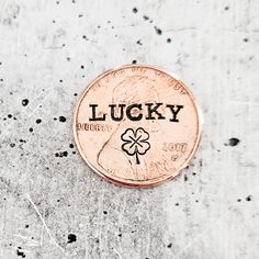 a penny with the word lucky written on it sitting on top of some concretes