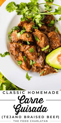 a white plate topped with meat and garnish next to an avocado