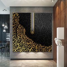 a black and gold wall with arabic writing on it in a dining room area next to a table