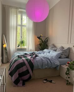 a bedroom with a bed, plant and lamp in it's centerpieces