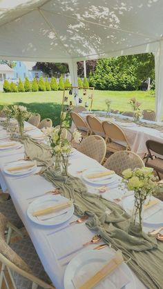 a table set up with plates and napkins for an outdoor wedding or party event