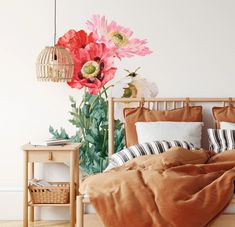 a bed with an orange comforter and some pink flowers