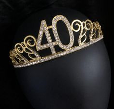 a gold tiara with the number forty four on it's headpiece, sitting on a black mannequin