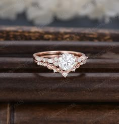 a diamond engagement ring sitting on top of a wooden table