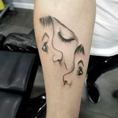 a woman's leg with a tattoo on it that has a face and eyes