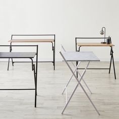 three tables and two chairs in an empty room