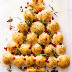 a christmas tree made out of rolls with rosemary sprigs and red pepper on top