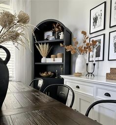 a dining room table with chairs and vases on it