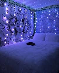 a bed with white fur and lights on the headboard is in front of a wall