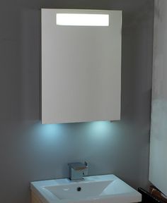 a white sink sitting under a bathroom mirror next to a wall mounted faucet