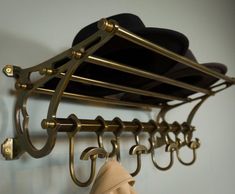 a hat and coat rack with hats hanging from it's hooks on the wall