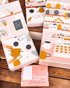 four pink and gold planner pages sitting on top of a wooden table next to each other