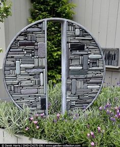 a metal sculpture sitting in the middle of a garden