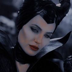 a close up of a woman with horns on her head and black hair wearing makeup