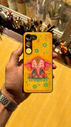 a person holding up a phone case with an elephant on it