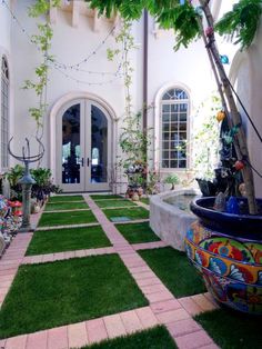 an outdoor courtyard with grass and potted plants