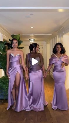 three women in long purple dresses walking down a hallway together with one holding the hand of another woman's hand