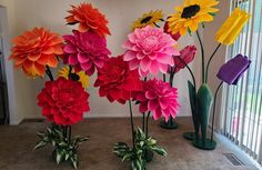 there are many different colored flowers in vases on the floor next to each other