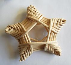 an ornament made out of bamboo sticks on a white surface