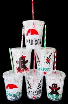 the cups are decorated with candy canes and santa hats on them, along with personalized drinking straws