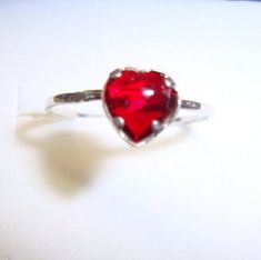 Little faceted red heart is 5 or 6mm and it is red garnet or some are red cz - in a silver setting.  I am currently out of the lab ruby.All metal is reclaimed/recycled and eco-friendly .925 sterling silver.Sweet little ring!The band is small and hammered lightly to facet it.   It would be cute on a mom, a little sister or daughter!Practically any size is available. I can do sizes: 1, 1½, 2, 2½, 3, 3½, 4, 4½, 5, 5½, 6, 6½, 7, 7½, 8, 8½, 9, 9½, 10, 10½, 11, 11½, 12, 12½, 13, 13½, 14, 14½, 15, 15½, Red Garnet, Recycled Sterling Silver, Stackable Rings, Little Sisters, Red Heart, Garnet, Ruby, Heart Ring, Custom Sizing