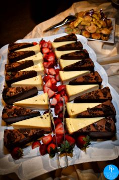 a platter filled with lots of different types of cheeses and strawberries on top of each other