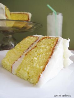 a slice of yellow cake sitting on top of a white paper towel covered in icing