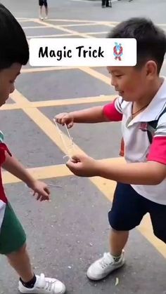 two young boys playing with a string in the street